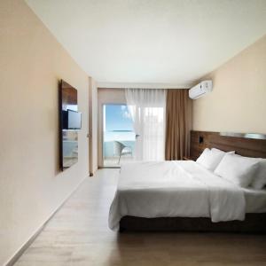 a bedroom with a large bed and a large window at Ozgur Bey Spa Hotel in Alanya