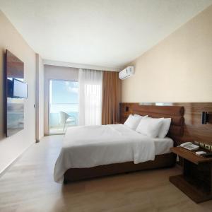 a bedroom with a large bed and a large window at Ozgur Bey Spa Hotel in Alanya