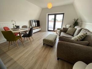a living room with a couch and a table at Swan View, Oulton Broad in Lowestoft