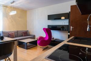 a living room with a pink chair and a couch at Apartament Na Urlop - Wisła Sarnia - apartament przyjazny zwierzętom in Wisła