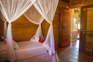 a bedroom with a bed with mosquito netting at Rancho do Kite Villas in Prea