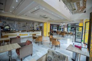 un restaurant avec des tables et des chaises et une cafétéria dans l'établissement Appart Hotel Rania, à Tanger
