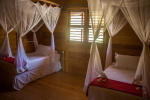 1 Schlafzimmer mit 2 Betten und Moskitonetzen in der Unterkunft Rancho do Kite Villas in Prea