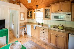 a kitchen with wooden cabinets and wooden floors at The Cottages at Cabot Cove in Kennebunkport