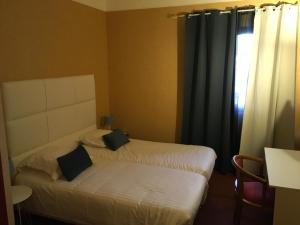 a hotel room with two beds and a window at Hotel Dorele in Montargis