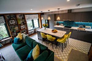 a kitchen with a green couch and a table with yellow chairs at Wuthering Heights in Sedbergh
