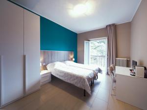 een slaapkamer met een bed en een blauwe muur bij I Dodici mesi rooms&apartments in Trento