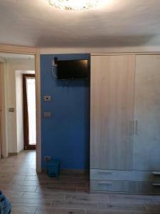 een woonkamer met een blauwe muur en een tv bij Casa vacanza la Rosa in Vinadio