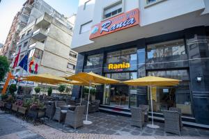 un restaurant avec des chaises et des parasols en face d'un bâtiment dans l'établissement Appart Hotel Rania, à Tanger