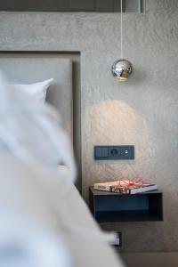 ein Schlafzimmer mit einem Bett und einem Nachttisch mit einer Lampe in der Unterkunft Appartementhotel Röhrenbach in Immenstaad am Bodensee