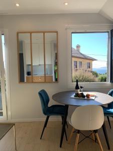 a dining room with a table and chairs and a window at Sereíña Beach in Vigo