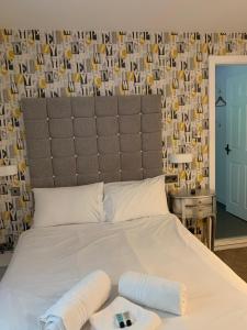 a bedroom with a large white bed with a large headboard at The Malthouse in Ironbridge