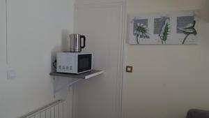 a microwave sitting on a shelf next to a door at Joli studio proche de DisneyLand Paris in Nanteuil-lès-Meaux