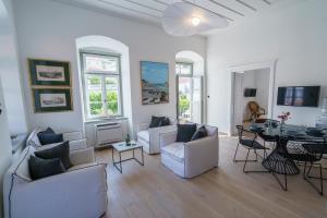 een woonkamer met witte meubels en een tafel bij Livin Hydra Private Collection Suite 3 in Hydra