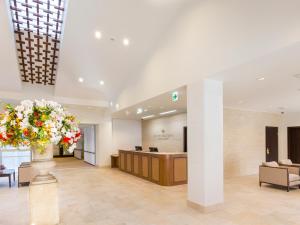 a lobby with a reception desk and a vase of flowers at Hotel Holistic Resort in Taiji