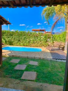 una piscina en un patio con una palmera en Casa de Temporada em Capitólio (Charme e Aconchego), en Capitólio