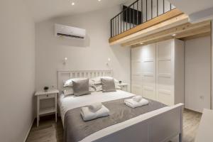 a white bedroom with a large bed with two pillows at Cosmijeva Luxury Rooms in Split