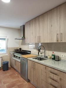 a kitchen with wooden cabinets and a stainless steel sink at HOSTEL LA CABAÑUELA in Monleras