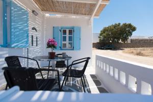 taras ze stołem i krzesłami na balkonie w obiekcie CASA DI MYKONOS w mieście Mykonos