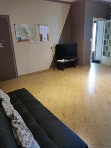 a living room with a couch and a flat screen tv at La Longère de Mina in La Petite-Boissière