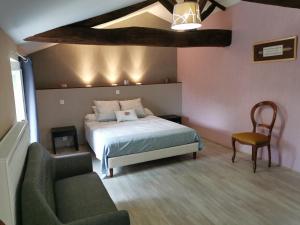 1 dormitorio con 1 cama, 1 silla y 1 sofá en La Longère de Mina en La Petite-Boissière