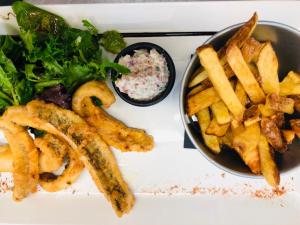 a plate of french fries and a bowl of salad at Logis Hôtels Gnàc é Pause in Saint-Lon-les-Mines