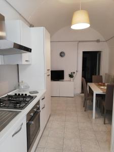 una cucina con piano cottura e tavolo con sala da pranzo di Santa Maria in Platea - Apartment a Montescaglioso
