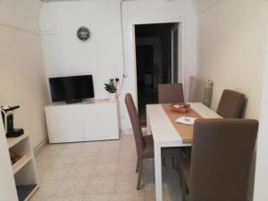 una sala da pranzo con tavolo, sedie e TV di Santa Maria in Platea - Apartment a Montescaglioso