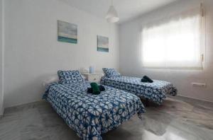 1 dormitorio con 2 camas y ventana en Villa gaviota, en Almuñécar