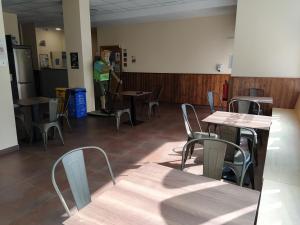 pokój ze stołami i krzesłami oraz osoba w oddali w obiekcie Senda Sur w mieście Porriño