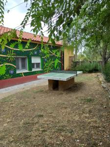 una mesa de ping pong frente a un edificio en HOSTEL LA CABAÑUELA, en Monleras