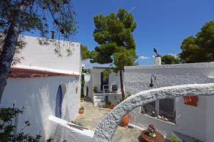 a white house with a tree in front of it at Rosys Little Village in Skala