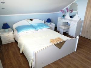 1 dormitorio con cama blanca y espejo en Agroturystyka Nowogród en Nowogród