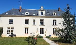 une grande maison blanche avec un toit noir dans l'établissement Le Manoir Domaine de la Motte, à Saint-Dyé-sur-Loire