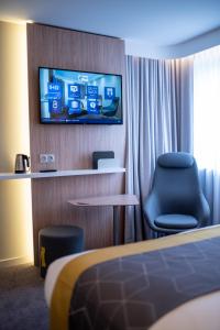 Habitación de hotel con cama, TV y silla en Holiday Inn Express - Arcachon - La Teste, an IHG Hotel en La Teste-de-Buch