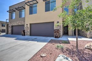a building with two garage doors and a tree at Luxury Downtown Moab Townhome with Pool Access! in Moab