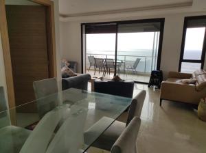 塞拉的住宿－Bel appartement à plage des Nation，客厅配有玻璃桌和椅子