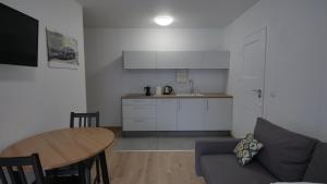 a kitchen with a table and chairs and a refrigerator at Joyful Apartments Sopot in Sopot