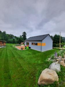 a house in a yard with rocks in the grass at Pod Sedlem in Loučná nad Desnou