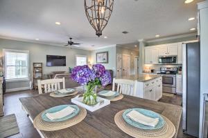a kitchen and dining room with a table with purple flowers at Modern and Spacious St Simons Home 4 Mi to Beach! in Ebo Landing