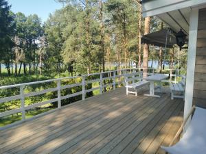 a wooden deck with a bench and an umbrella at Sosnowy Azyl in Wąglikowice