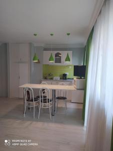 a kitchen with a table and chairs in a room at Brill Apartman in Harkány
