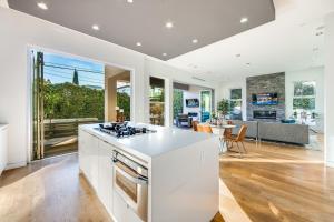 uma cozinha com uma ilha branca e uma sala de estar em Drexel Villa em Los Angeles