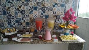 a kitchen counter with food and drinks on it at Pousada Recanto da Enseada in Cabo de Santo Agostinho