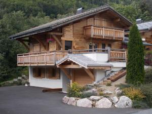 a large wooden house with a porch and a balcony at Chalet Jonquille in Les Gets