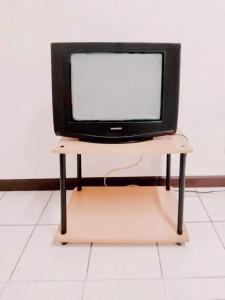 una tv seduta su un supporto su un tavolo di Pacific Apt a Bang Na