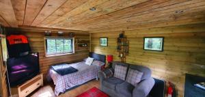 Habitación con cama y sofá en una cabaña en Miners log cabin, en Blaina