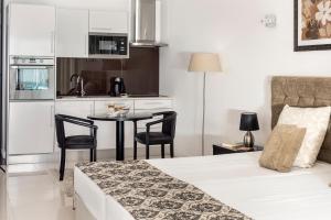 a bedroom with a bed and a kitchen with a table at Belmar Spa & Beach Resort in Lagos