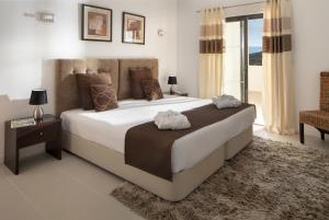 a bedroom with a large bed with two towels on it at Belmar Spa & Beach Resort in Lagos