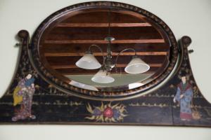 a mirror with two lights on a wall at El ático de los mosaicos in Cádiz